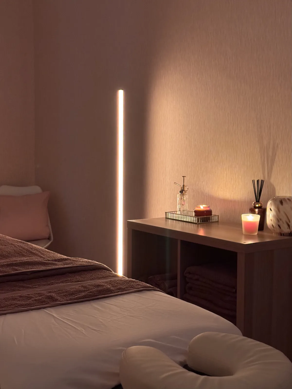 Sala de massagens em Almada preparada com marquesa, toalhas e luz ambiente.